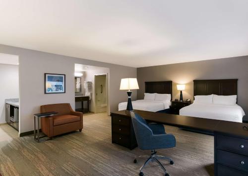 纽瓦克威尔明顿克里斯蒂娜汉普顿酒店及套房的酒店客房 - 带两张床、一张桌子和一把椅子