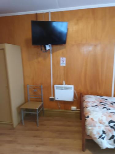瓦尔迪维亚Hotel CasaGrande的卧室配有一张床,墙上配有电视。