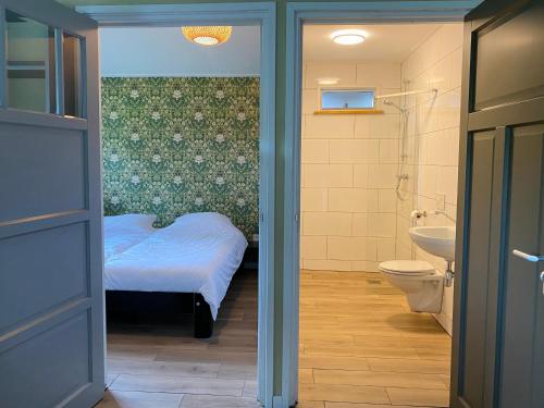 LeuvenheimGastenverblijf in rustige groene omgeving - Kievit Leuvenheim的一间带床、水槽和卫生间的浴室