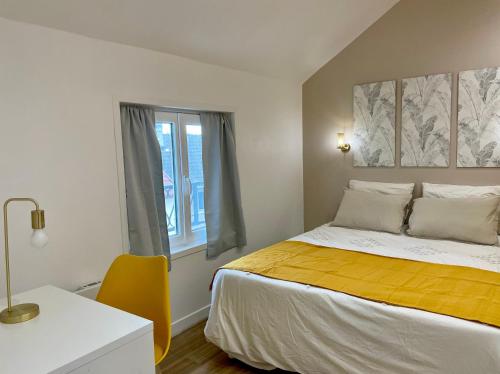勒布尔热Le Cocon - logement 4 personnes - Neuf - Wifi的一间卧室配有一张床、一张书桌和一个窗户。
