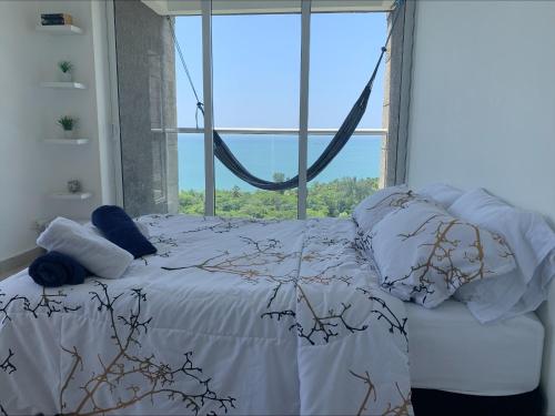 圣玛尔塔Amazing Penthouse. A minutos de la playa.的一张位于带大窗户的房间内的床铺