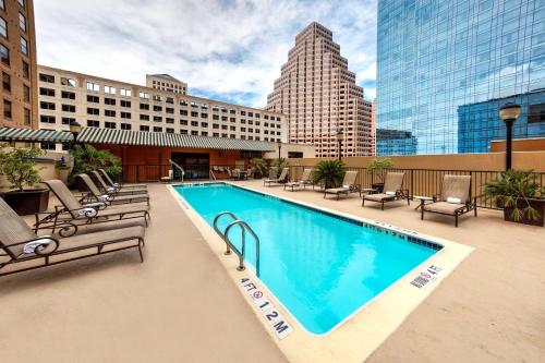 奥斯汀Hampton Inn & Suites Austin-Downtown/Convention Center的一座带椅子的大型游泳池和一座建筑