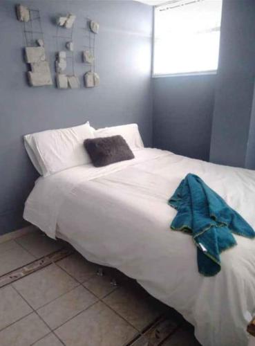波哥大Cómoda y muy bien ubicada的一张白色的大床,上面有蓝色的毛巾
