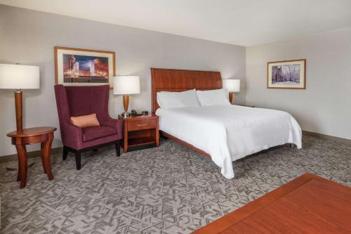 布莱克斯堡Hilton Garden Inn Blacksburg University的配有一张床和一把椅子的酒店客房