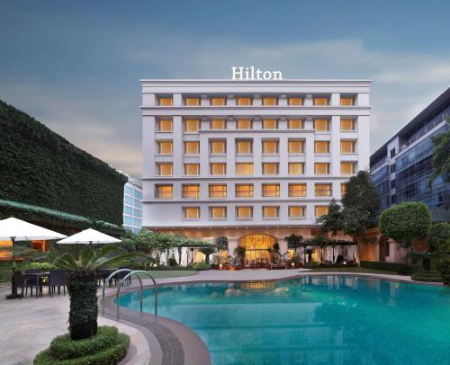 孟买希尔顿孟买国际机场酒店的大楼前设有游泳池的酒店