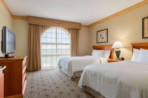 哥伦比亚Embassy Suites by Hilton Columbia Greystone的酒店客房设有两张床和一台平面电视。