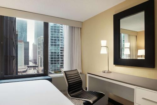 芝加哥芝加哥壮丽大道希尔顿逸林酒店的酒店客房设有一张床和一个大窗户