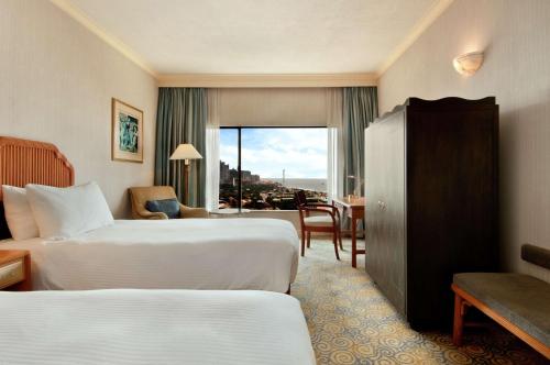 科伦坡科伦坡希尔顿酒店的酒店客房设有两张床、一张书桌和一个窗户。