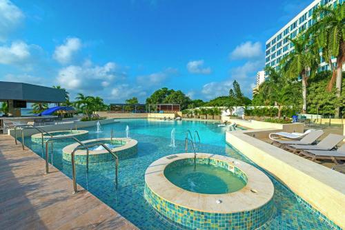 卡塔赫纳卡塔赫纳希尔顿酒店的一座带椅子的大型游泳池和一座建筑