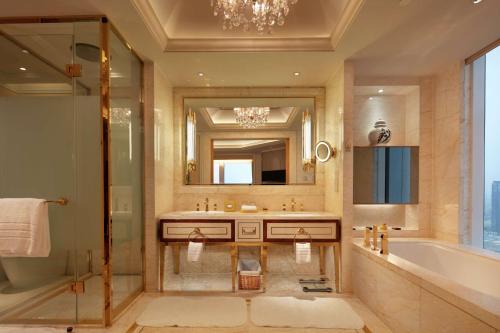 大连大连康莱德酒店的带浴缸、水槽和镜子的浴室
