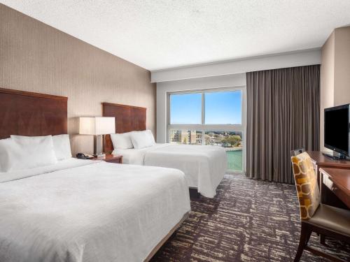 弗赖拉辛Embassy Suites by Hilton Dallas Frisco Hotel & Convention Center的酒店客房设有两张床和电视。