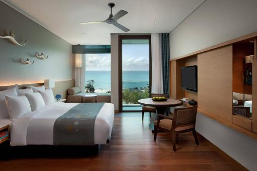 港生Rayong Marriott Resort & Spa的一间卧室配有一张床、一张桌子和一台电视