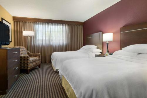 德梅因得梅因市中心大使套房酒店的酒店客房,配有两张床和椅子