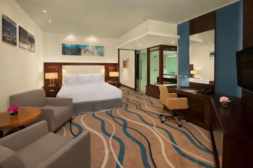 迪拜DoubleTree by Hilton Hotel and Residences Dubai – Al Barsha的配有一张床和一张书桌的酒店客房