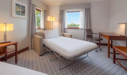 达宁顿堡希尔顿动米德兰机场酒店的配有一张床和一张书桌的酒店客房