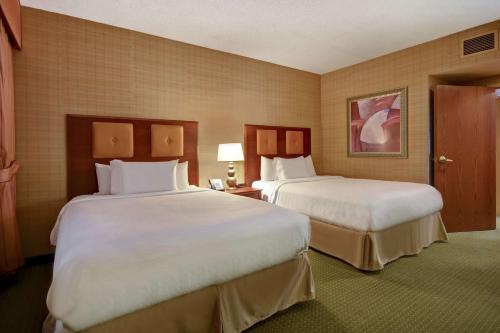 温泉城温泉市大使馆酒店暨Spa的酒店客房,配有两张带白色床单的床
