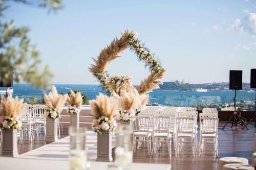 伊斯坦布尔康拉德伊斯坦布尔博斯普鲁斯酒店的桌椅和鲜花盛开的婚礼拱门