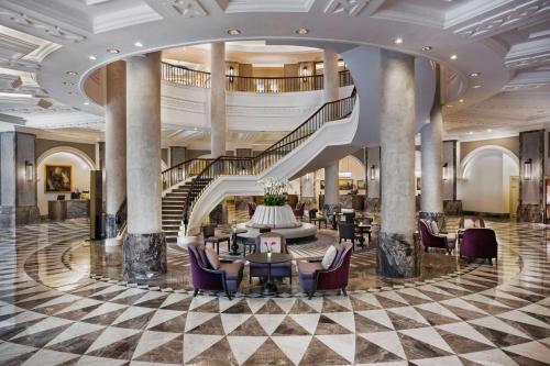 伊斯坦布尔康拉德伊斯坦布尔博斯普鲁斯酒店的大堂设有螺旋楼梯和桌椅