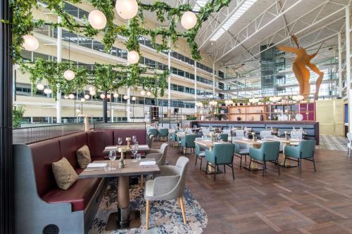 希灵登Hilton London Heathrow Airport的大楼内带桌椅的餐厅