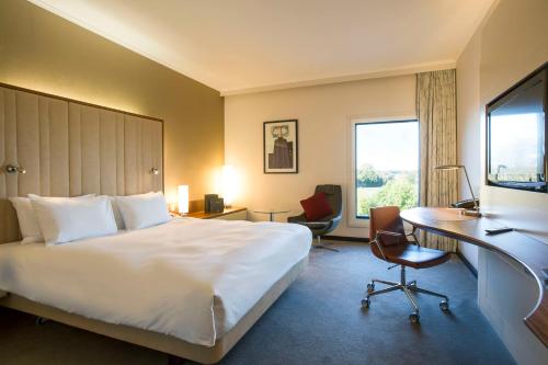 希灵登希尔顿伦敦希思罗机场5号航站楼酒店的酒店客房设有一张大床和一张书桌。