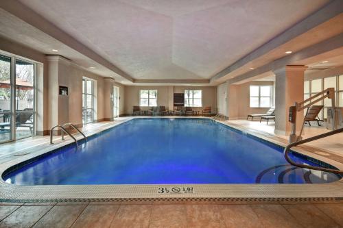 小石城小石城希尔顿合博套房酒店的大楼内一个蓝色的大型游泳池