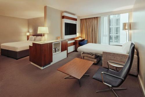 伦敦伦敦塔希尔顿逸林酒店的酒店客房 - 带两张床、一张桌子和一把椅子