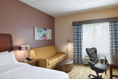 洪美尔斯镇赫尔希希尔顿花园旅馆的酒店客房配有一张床、一张桌子和一把椅子。