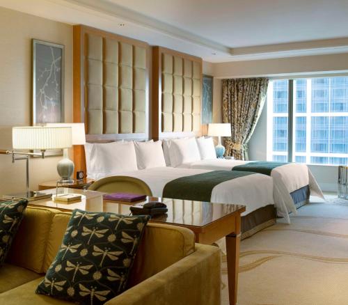 澳门澳门康莱德酒店的酒店客房设有一张大床和一张沙发。