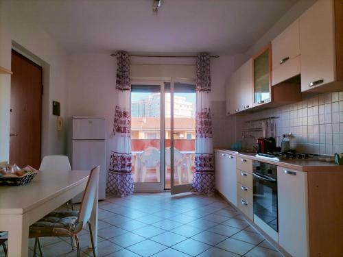 圣萨尔沃Appartamento Solaris 200 m dal mare的厨房配有桌子、桌子和窗户