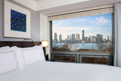 纽约Conrad New York Downtown的卧室设有大窗户,享有城市美景。