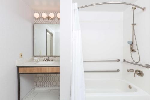 圣莱安德罗奥克兰/圣林德罗希尔顿花园旅馆的白色的浴室设有浴缸和水槽。