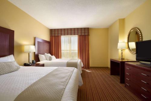 诺曼Embassy Suites by Hilton Norman Hotel & Conference Center的酒店客房设有两张床和一台平面电视。