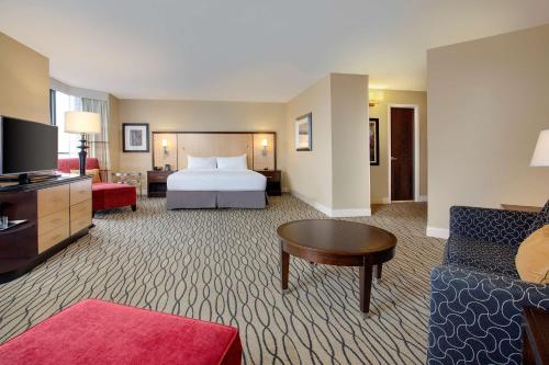 罗斯芒特芝加哥奥黑尔希尔顿罗斯蒙特酒店的酒店客房设有床和客厅。