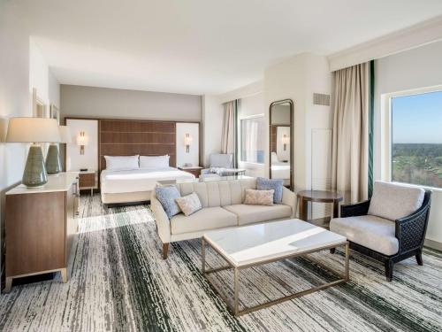 奥兰多Signia by Hilton Orlando Bonnet Creek的酒店客房设有一张特大号床和一间客厅。