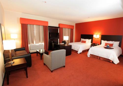 钱德勒凤凰城钱德勒时装中心汉普顿酒店及套房的酒店客房,设有两张床和红色的墙壁