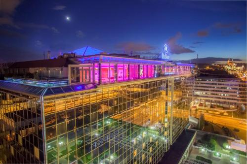 布拉格布拉格希尔顿酒店的一座晚上在上面有紫色灯的建筑