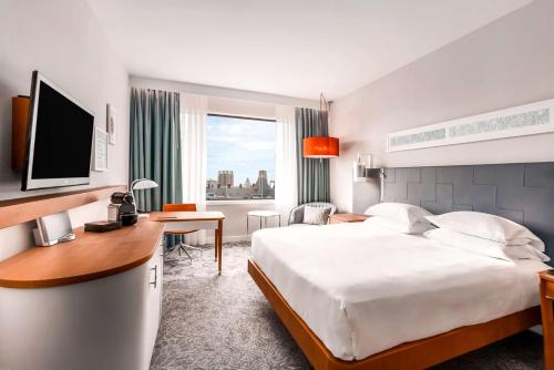 鹿特丹鹿特丹希尔顿酒店的酒店客房配有一张床、一张书桌和一台电视。