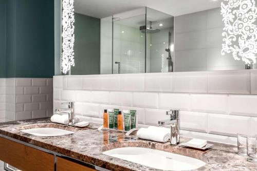 鹿特丹鹿特丹希尔顿酒店的一间带两个盥洗盆和大镜子的浴室
