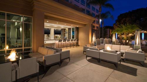 圣地亚哥DoubleTree by Hilton San Diego Del Mar的一个带白色椅子的庭院和夜间酒吧