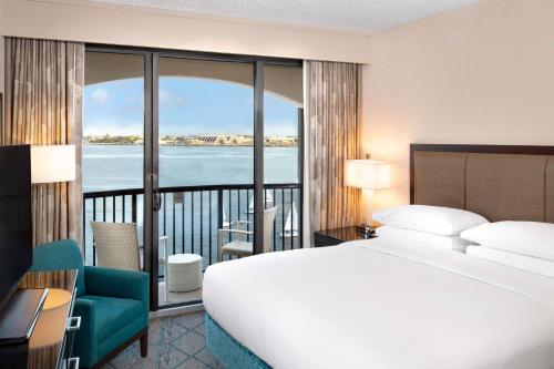 圣地亚哥圣地亚哥机场哈勃尔岛希尔顿酒店的一间卧室配有一张床,享有水景