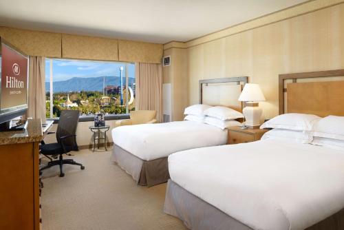 圣克拉拉希尔顿圣塔克拉酒店的酒店客房设有两张床和一台平面电视。