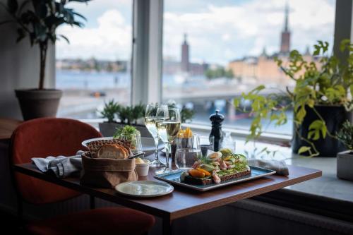 斯德哥尔摩斯德哥尔摩斯拉森希尔顿酒店的一张桌子,上面放着一盘食物和一杯葡萄酒