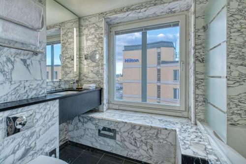 斯德哥尔摩斯德哥尔摩斯拉森希尔顿酒店的一间带窗户和水槽的浴室