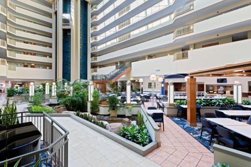 坦帕Embassy Suites by Hilton Tampa USF Near Busch Gardens的大楼内带桌椅的餐厅