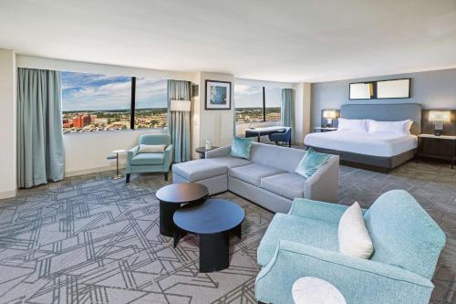 塔尔萨图尔萨市中心希尔顿逸林酒店的酒店客房设有床和客厅。