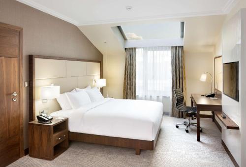 华沙华沙希尔顿逸林酒店及会议中心的酒店客房配有一张床、一张书桌和一台电脑