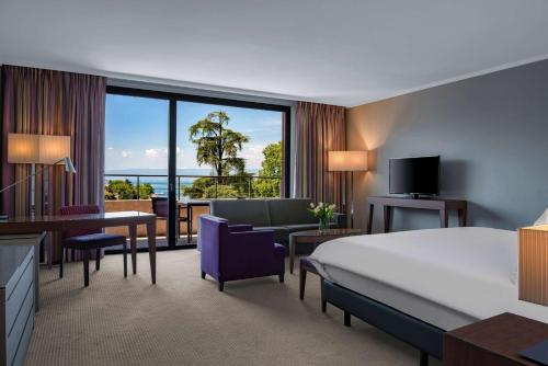 埃维昂莱班希尔顿伊凡乐班酒店的配有一张床和一张书桌的酒店客房