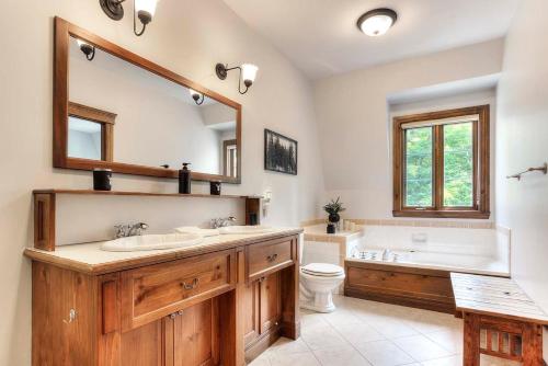 蒙特朗布朗Sweet Getaway的一间带两个盥洗盆、浴缸和卫生间的浴室