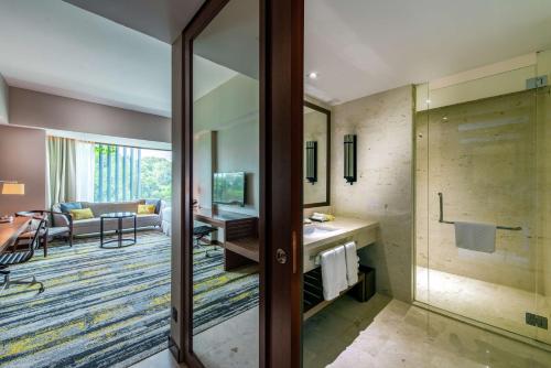 哥打京那巴鲁哥打京那巴鲁希尔顿酒店的浴室设有玻璃门,可通往客厅