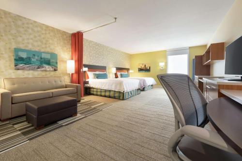 罗斯维尔Home2 Suites by Hilton Roseville Minneapolis的酒店客房,配有床和沙发